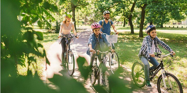 family riding bike in park
