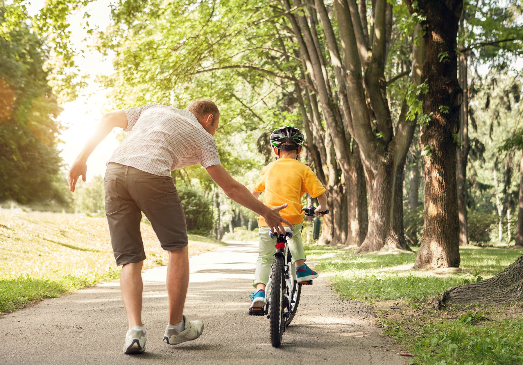 father-teaching-son-to-ride-bike-neighborhood