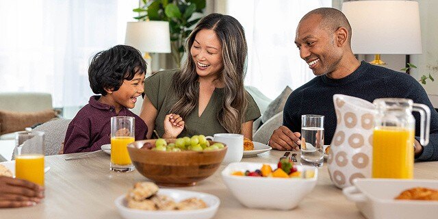 young family eating breakfast in single family home