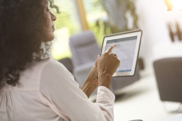 Woman using tablet to operate smart home technology