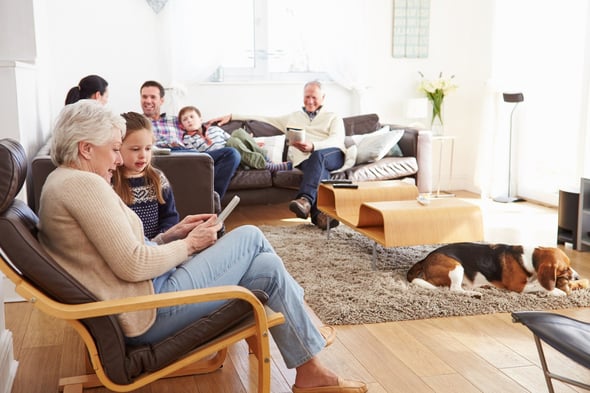 Image of family and dog gathered in their brightly lit living room