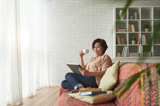 Woman relaxing in living room with books and a cup of coffee